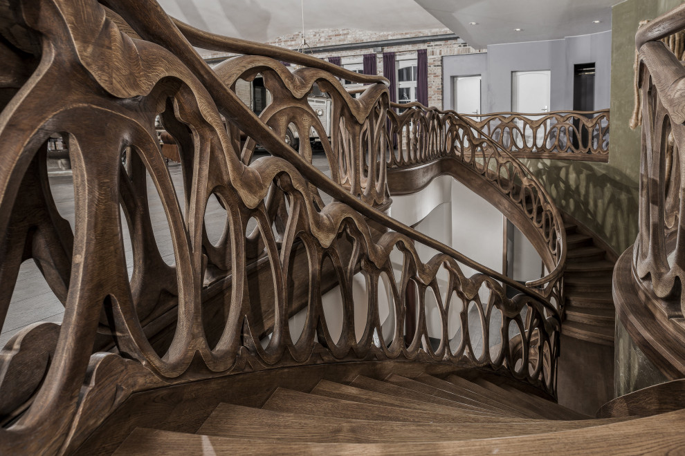 Réalisation d'un très grand escalier peint courbe bohème avec des marches en bois peint et un garde-corps en bois.