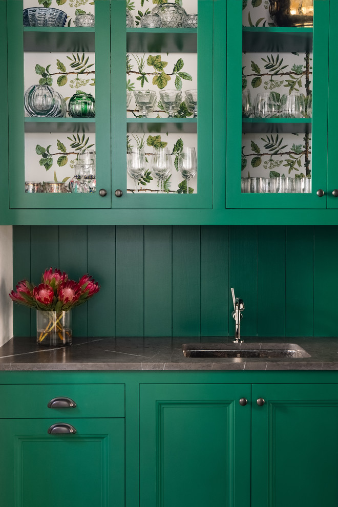 Photo of a large transitional single-wall wet bar in Austin with green cabinets, an undermount sink, glass-front cabinets, green splashback, timber splashback and grey benchtop.