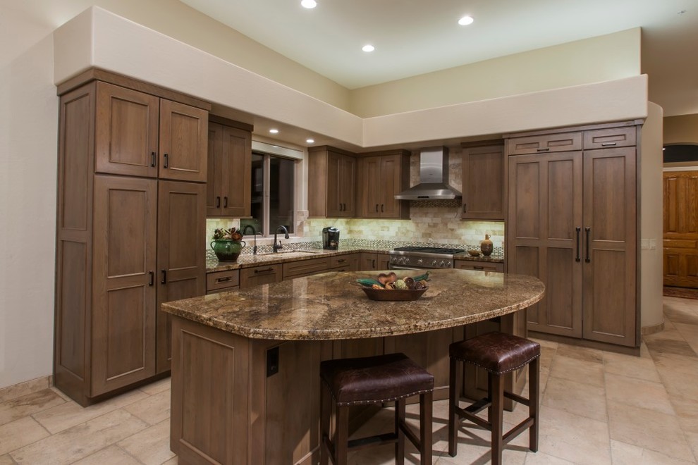 Photo of a large traditional l-shaped separate kitchen in Phoenix with an undermount sink, shaker cabinets, granite benchtops, beige splashback, stone tile splashback, stainless steel appliances, limestone floors, with island, beige floor, medium wood cabinets and brown benchtop.