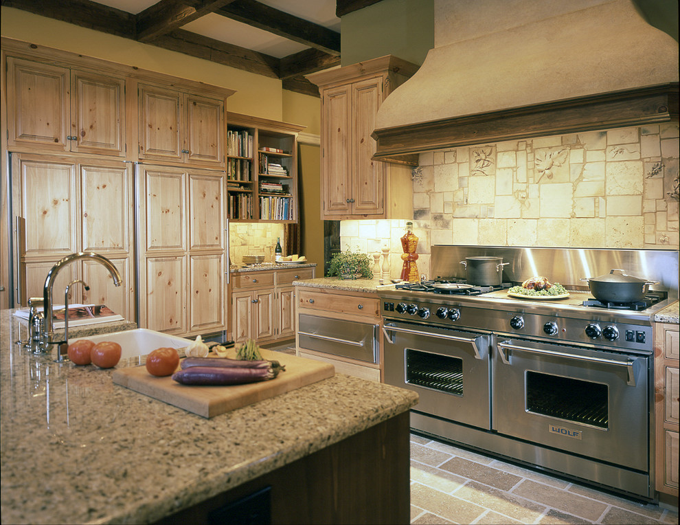 Inspiration for a large rustic l-shaped beige floor enclosed kitchen remodel in Raleigh with a farmhouse sink, raised-panel cabinets, light wood cabinets, granite countertops, beige backsplash, stainless steel appliances and an island