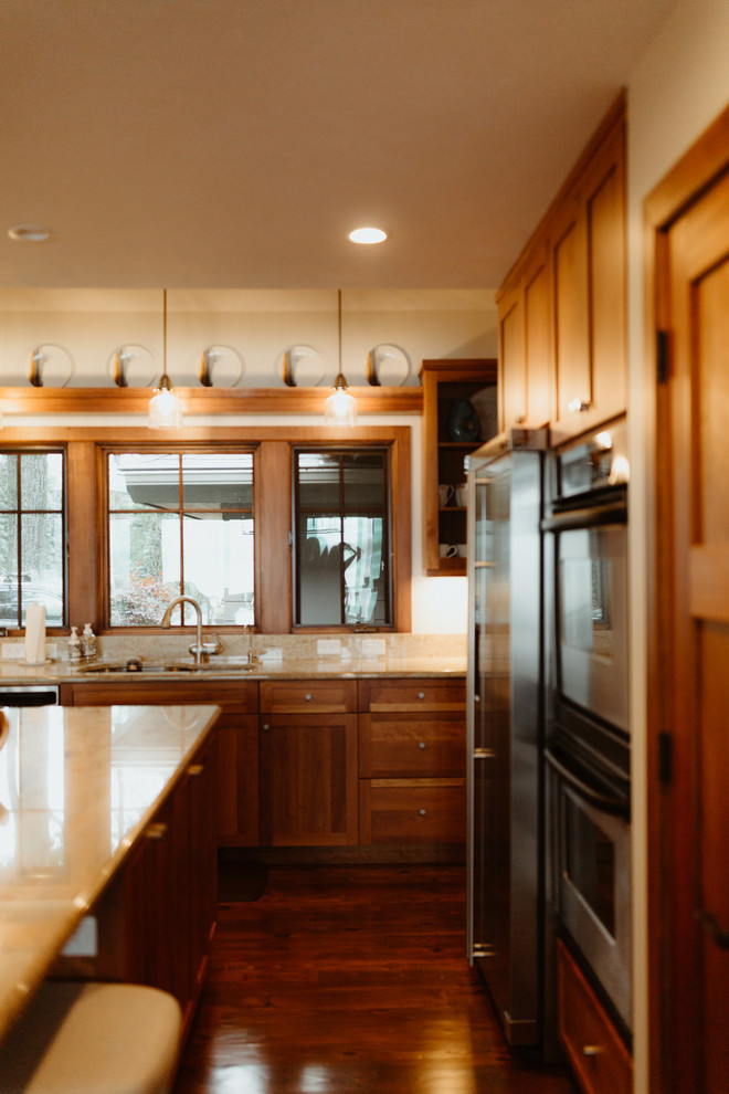 Inspiration for a large modern enclosed kitchen remodel with dark wood cabinets, stainless steel appliances, an island and beige countertops