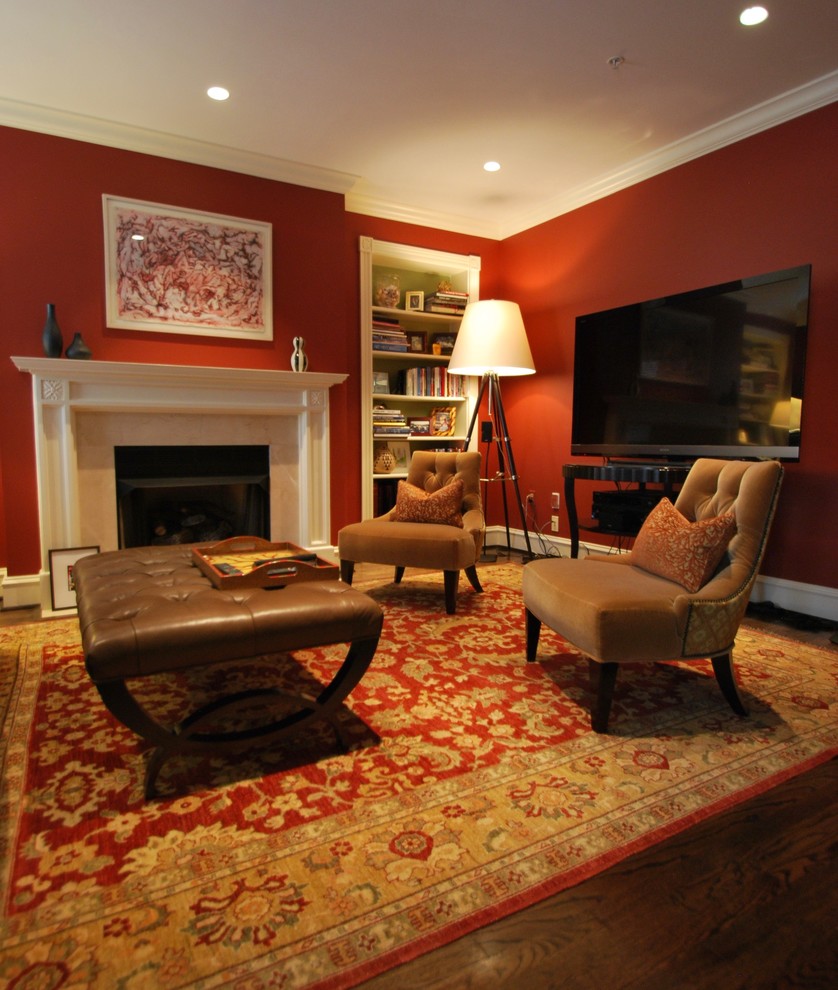 Inspiration for a mid-sized transitional enclosed family room with red walls, dark hardwood floors, a standard fireplace, a stone fireplace surround, a freestanding tv and brown floor.