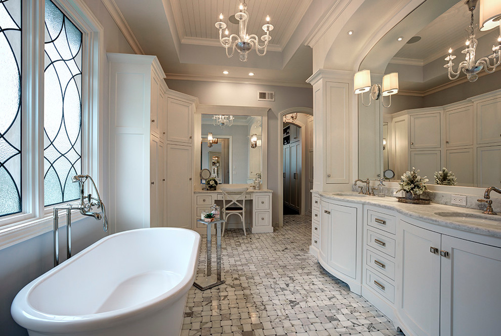 This is an example of an expansive traditional master bathroom in Kansas City with flat-panel cabinets, white cabinets, a freestanding tub, a curbless shower, a two-piece toilet, grey walls, marble floors, an undermount sink, marble benchtops, multi-coloured floor, a hinged shower door and multi-coloured benchtops.