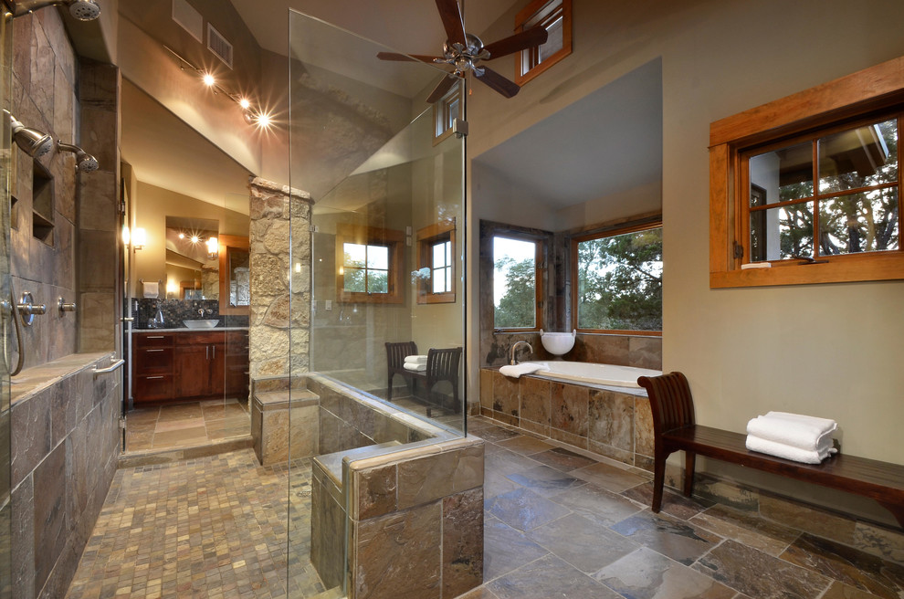 Photo of a country bathroom in Austin with a vessel sink, an alcove tub, a double shower, brown tile, dark wood cabinets, brown floor and slate.