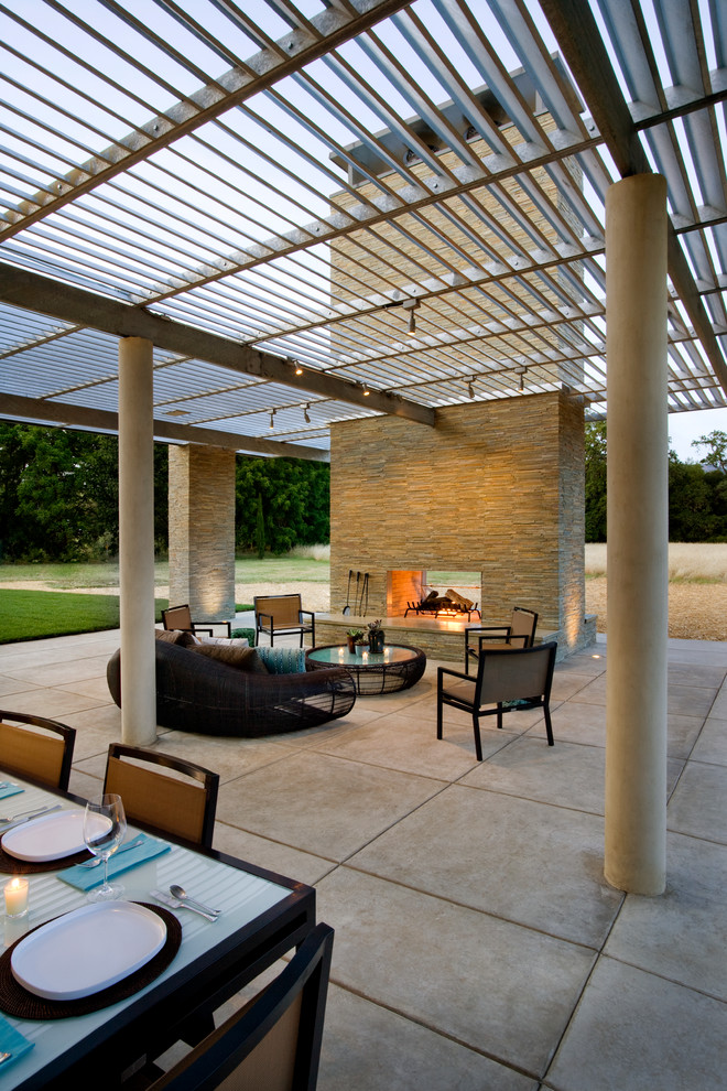 Expansive modern backyard patio in San Francisco with a fire feature, concrete slab and a roof extension.