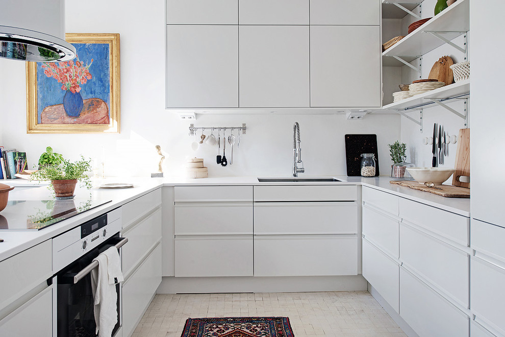 Photo of a large scandinavian u-shaped kitchen in Gothenburg with flat-panel cabinets, white cabinets, white appliances, ceramic floors and no island.