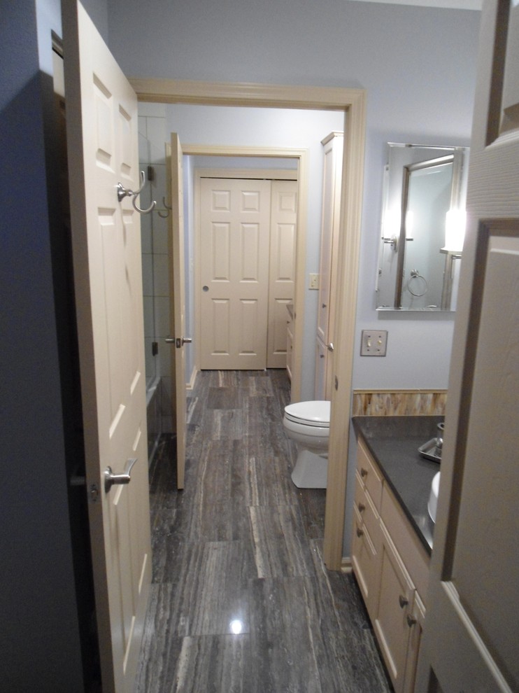 This is an example of a mid-sized traditional bathroom in Milwaukee with raised-panel cabinets, beige cabinets, beige tile, matchstick tile, grey walls, porcelain floors, a drop-in sink, granite benchtops and grey floor.