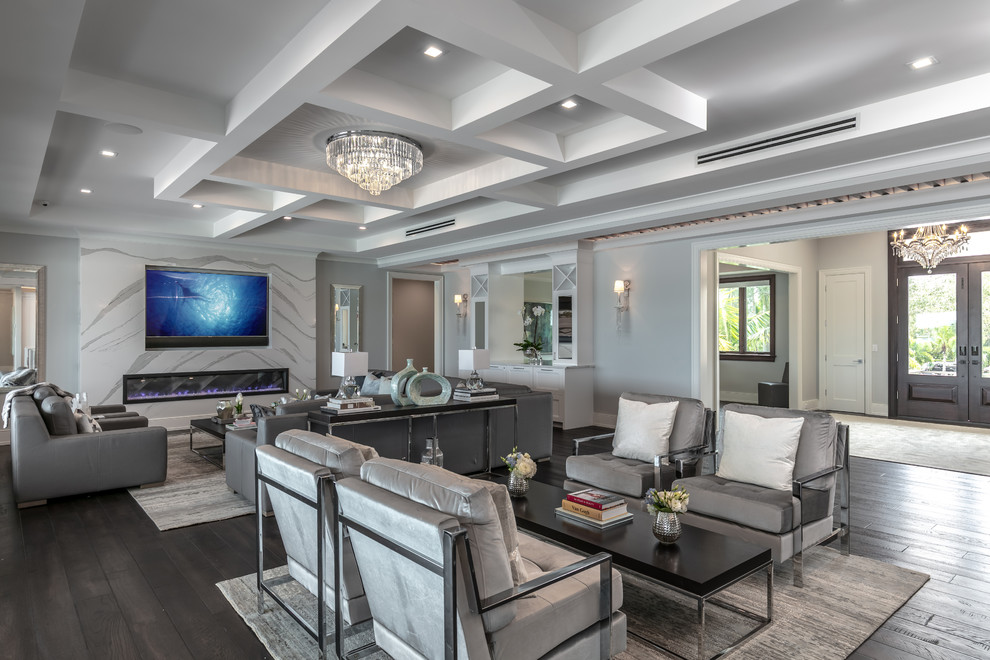 This is an example of a beach style open concept family room in Tampa with grey walls, dark hardwood floors, a ribbon fireplace and a wall-mounted tv.