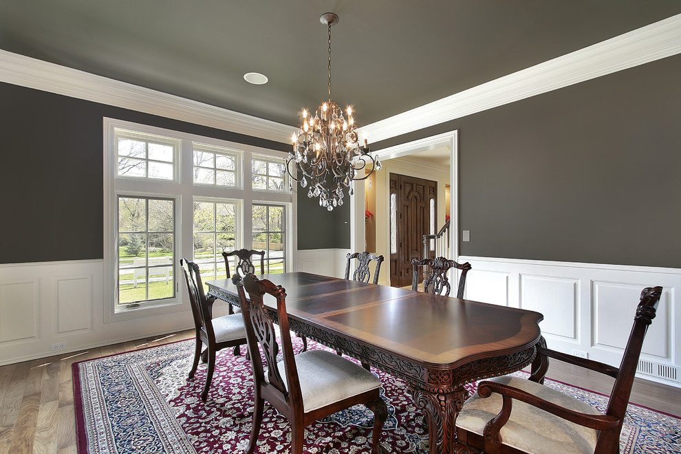 Inspiration for a traditional dining room in Louisville with green walls and medium hardwood floors.