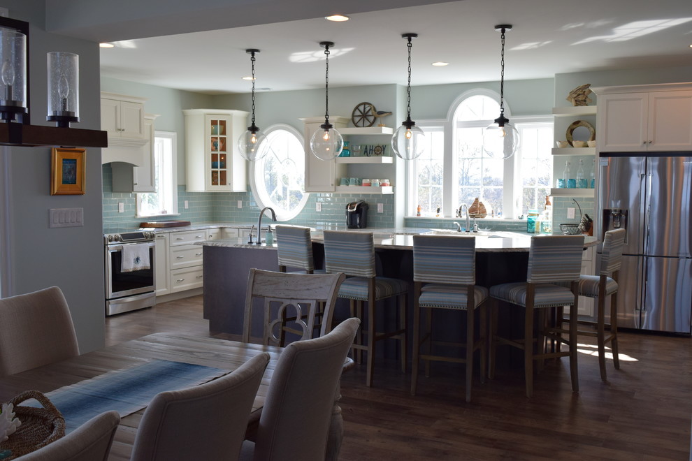 Kitchen - coastal medium tone wood floor kitchen idea with recessed-panel cabinets, an island, a double-bowl sink, white cabinets, quartz countertops, blue backsplash, ceramic backsplash and stainless steel appliances