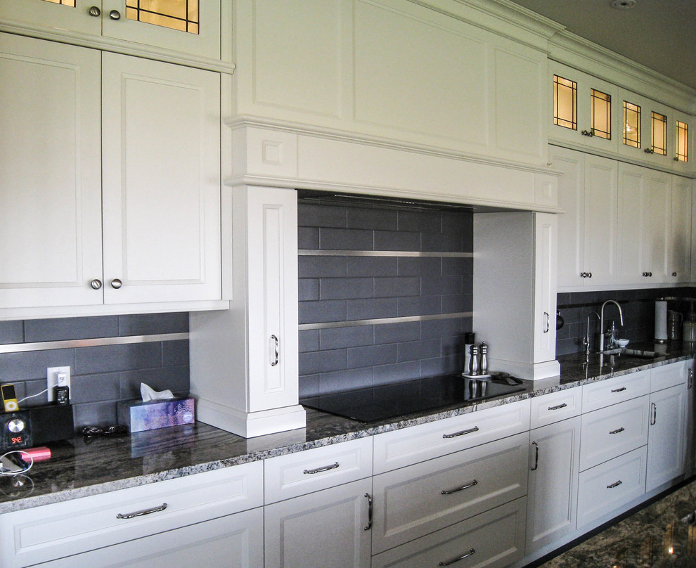 Eat-in kitchen - transitional l-shaped gray floor eat-in kitchen idea in Toronto with an undermount sink, white cabinets, granite countertops, gray backsplash, stainless steel appliances and an island