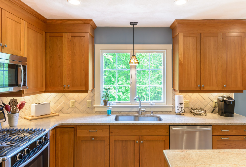 Large arts and crafts l-shaped eat-in kitchen in Boston with beige splashback, subway tile splashback, stainless steel appliances, an undermount sink, shaker cabinets, medium wood cabinets, granite benchtops, marble floors, with island and white floor.