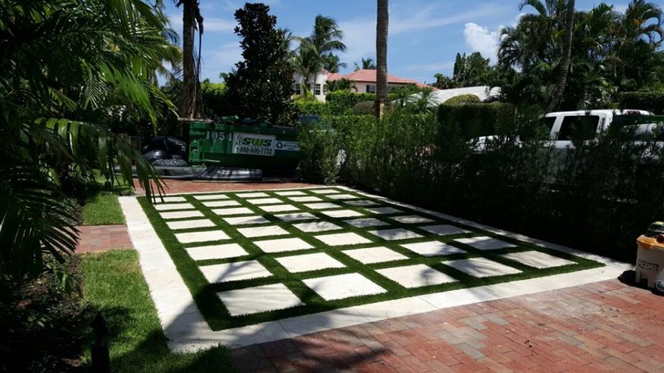 This is an example of a large modern front yard partial sun driveway for spring in Tampa with a garden path and concrete pavers.