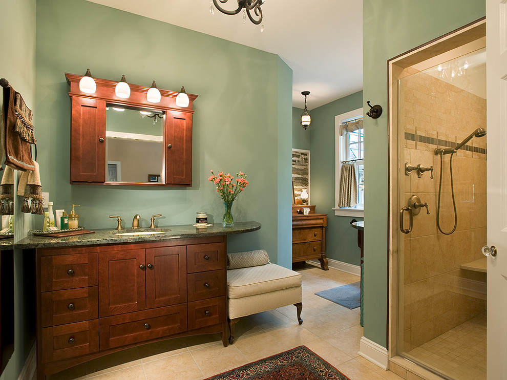 Inspiration for a large traditional master bathroom in Philadelphia with an undermount sink, shaker cabinets, dark wood cabinets, an alcove shower, green walls, a two-piece toilet, limestone floors, granite benchtops, beige floor, a hinged shower door and green benchtops.