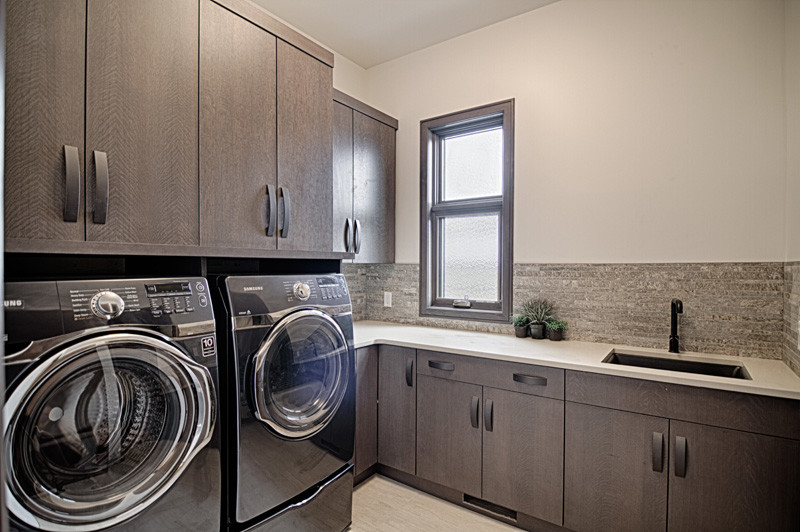 Inspiration for a transitional laundry room in Calgary with an undermount sink, flat-panel cabinets, medium wood cabinets, quartz benchtops, beige walls, ceramic floors and a side-by-side washer and dryer.