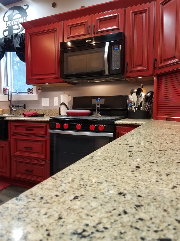 L-shaped slate floor and multicolored floor enclosed kitchen photo in Cedar Rapids with a double-bowl sink, beaded inset cabinets, red cabinets, black appliances, no island and brown countertops