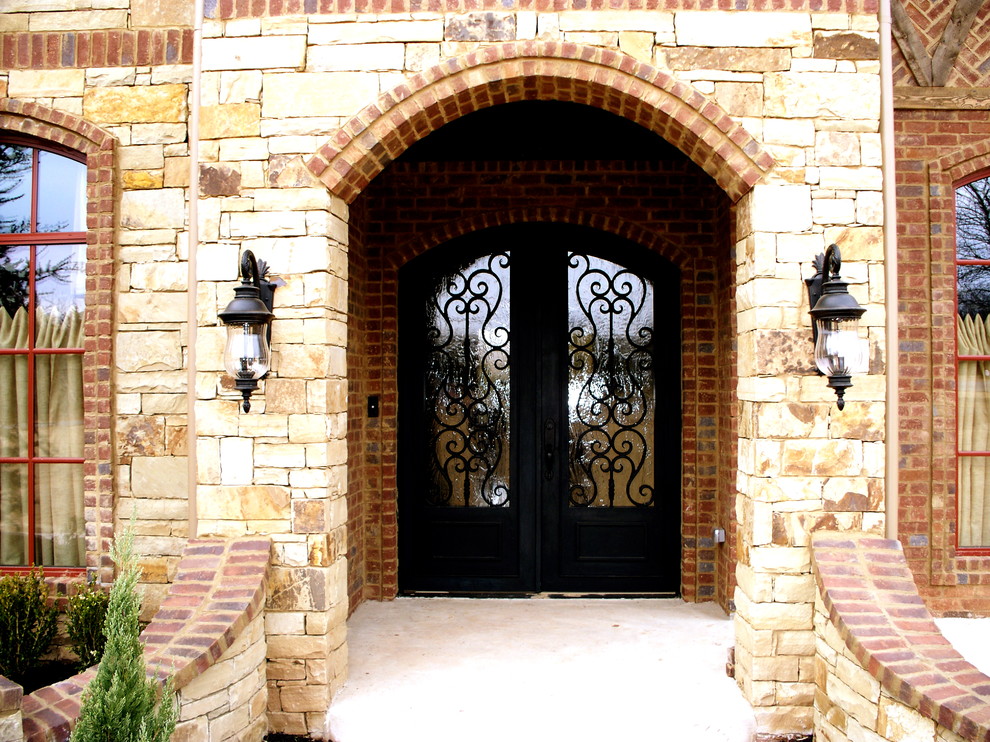 Large traditional front door in Oklahoma City with beige walls, concrete floors, a double front door and a metal front door.