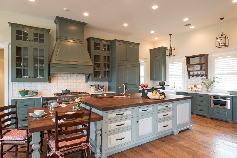 Inspiration for a traditional eat-in kitchen in Charlotte with a single-bowl sink, glass-front cabinets, wood benchtops, stainless steel appliances, medium hardwood floors and with island.