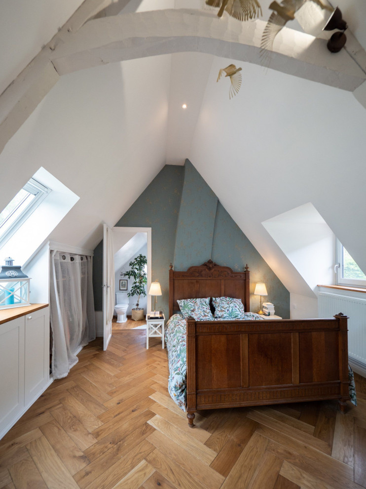 Großes Country Hauptschlafzimmer mit grüner Wandfarbe, hellem Holzboden, freigelegten Dachbalken und Tapetenwänden in Le Havre
