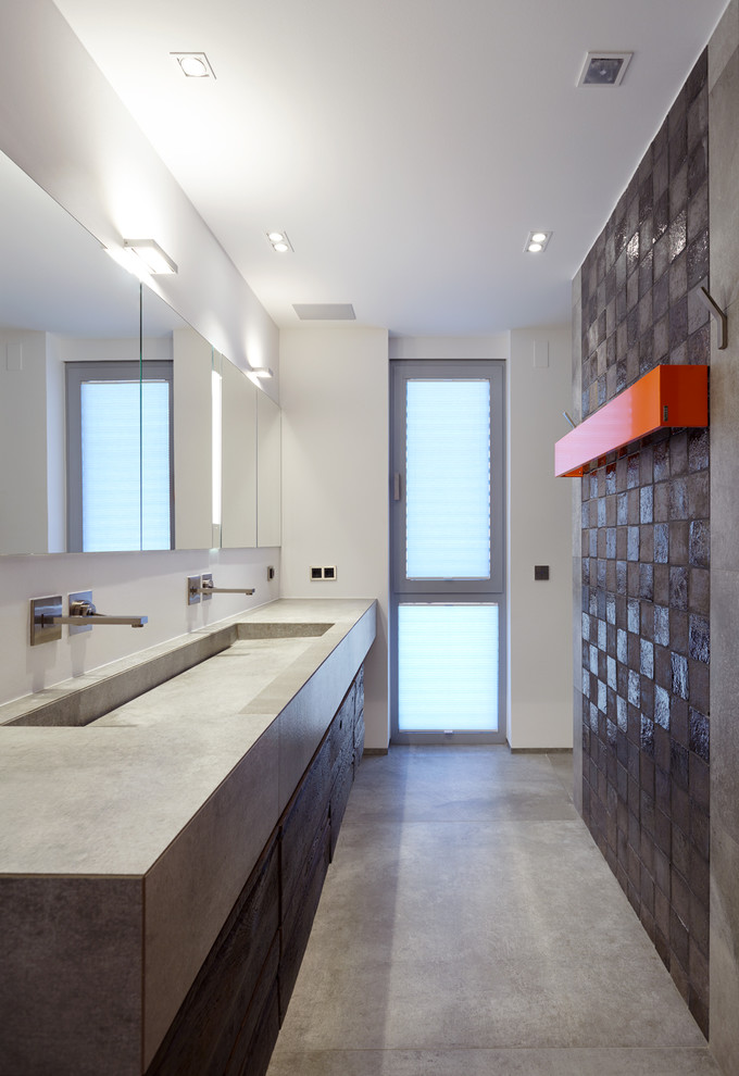 Large industrial 3/4 bathroom in Cologne with dark wood cabinets, a curbless shower, a wall-mount toilet, gray tile, terra-cotta tile, white walls, ceramic floors, an integrated sink, tile benchtops, grey floor and grey benchtops.