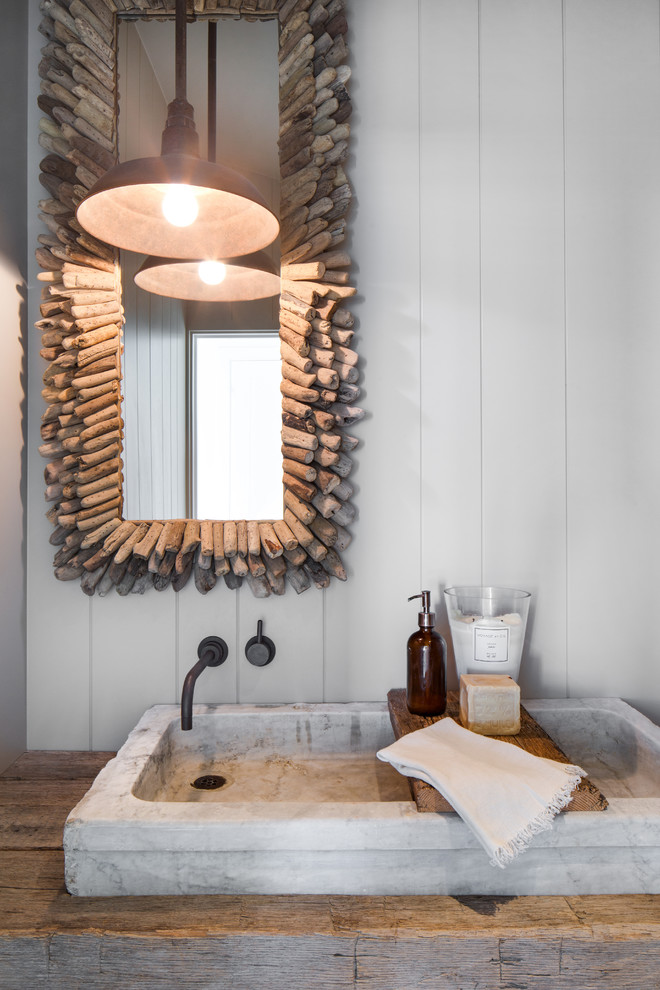 Bathroom - coastal bathroom idea in Orange County with white walls, a vessel sink, wood countertops and brown countertops
