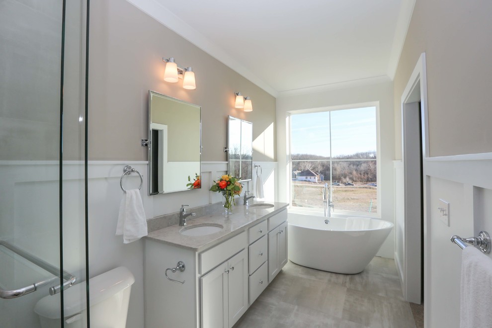 This is an example of a transitional bathroom in Richmond with white cabinets, a freestanding tub, a double shower, a one-piece toilet, an undermount sink and a sliding shower screen.