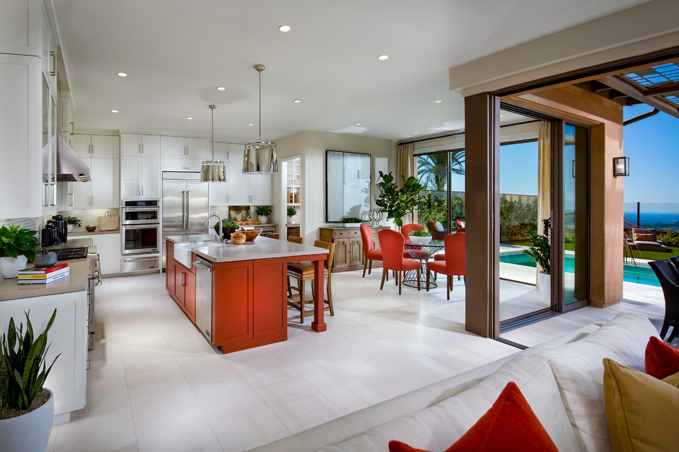 Inspiration for a beach style l-shaped open plan kitchen in Orange County with a farmhouse sink, shaker cabinets, red cabinets, white splashback, stainless steel appliances, with island, white floor and white benchtop.