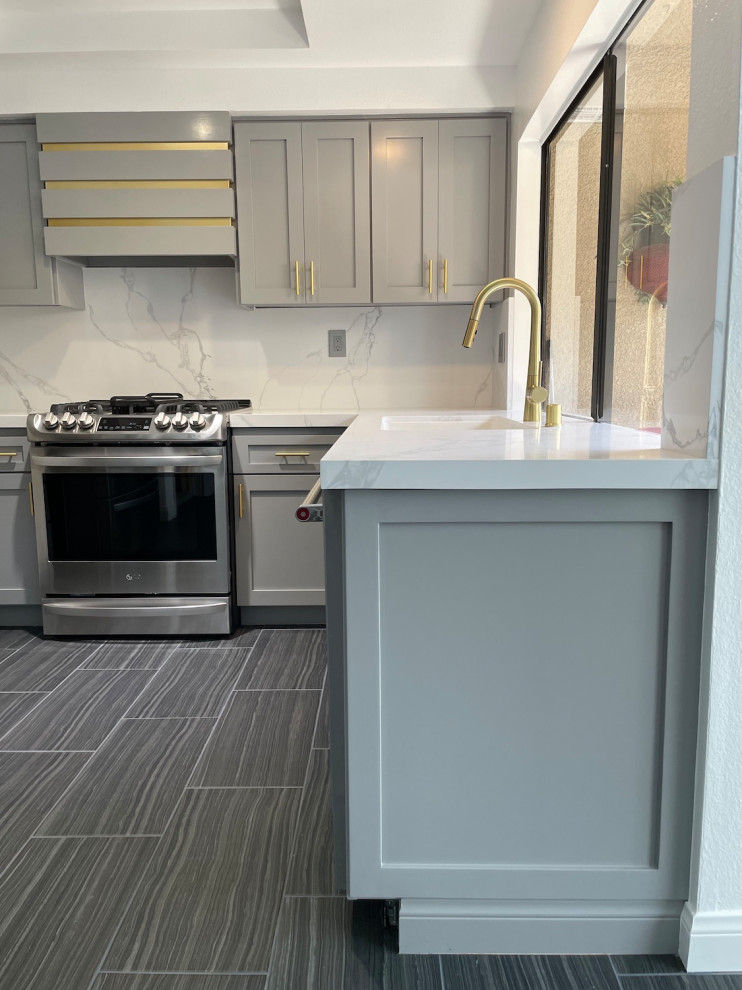 Small contemporary u-shaped eat-in kitchen in Los Angeles with a double-bowl sink, shaker cabinets, grey cabinets, quartz benchtops, white splashback, engineered quartz splashback, coloured appliances, porcelain floors, no island, blue floor and white benchtop.