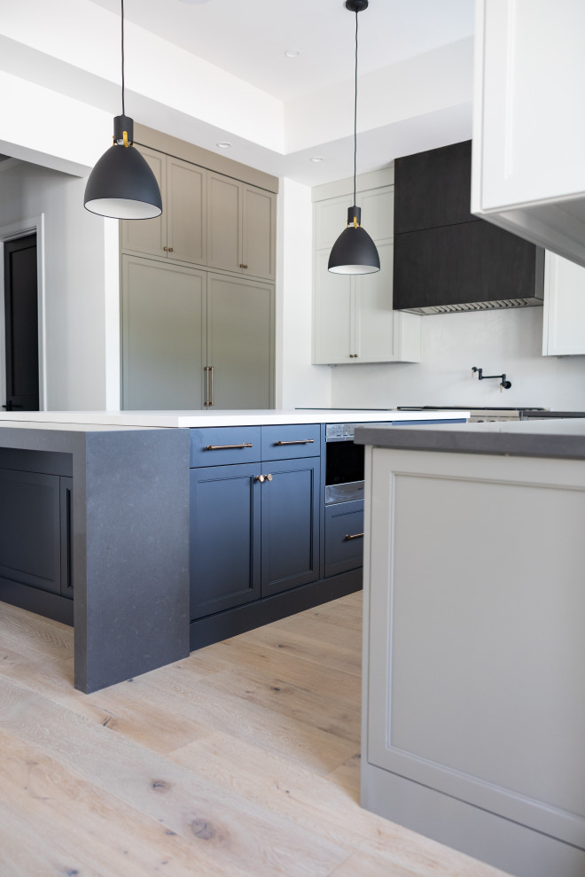 Inspiration for a large transitional galley open concept kitchen remodel in Phoenix with an integrated sink, recessed-panel cabinets, gray cabinets, marble countertops, white backsplash, marble backsplash, paneled appliances, an island and white countertops