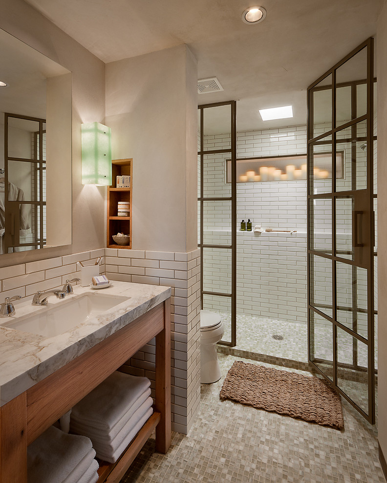 Design ideas for a large country 3/4 bathroom in Phoenix with an alcove shower, a two-piece toilet, white tile, subway tile, beige walls, an undermount sink, quartzite benchtops, beige floor, a hinged shower door and white benchtops.