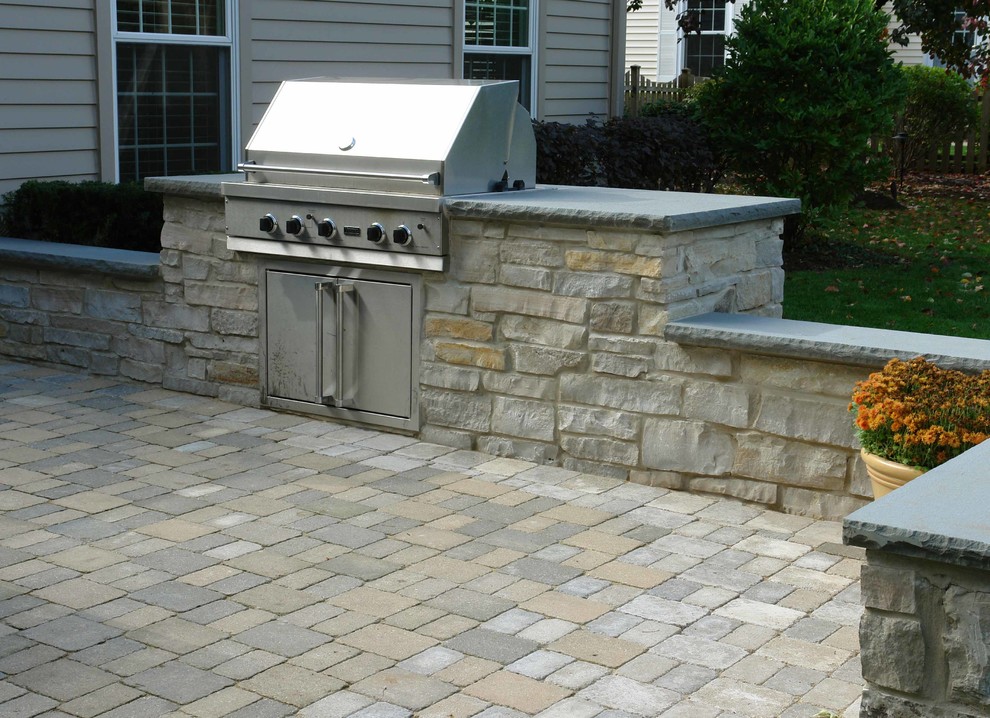 Photo of a large traditional backyard patio in Chicago with an outdoor kitchen, brick pavers and no cover.