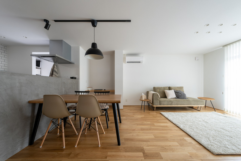 他の地域にある中くらいなインダストリアルスタイルのおしゃれなLDK (白い壁、無垢フローリング、クロスの天井、壁紙、白い天井) の写真