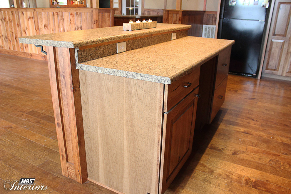 Example of a mountain style l-shaped kitchen design in Columbus with recessed-panel cabinets, medium tone wood cabinets, laminate countertops and black appliances