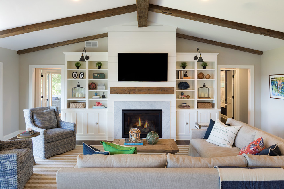 This is an example of a transitional open concept family room in Minneapolis with white walls, dark hardwood floors, a standard fireplace, a tile fireplace surround, a wall-mounted tv and brown floor.