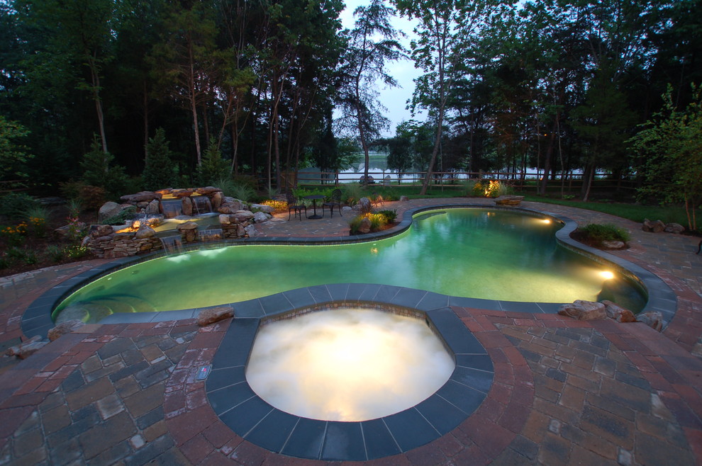 Inspiration for a large transitional backyard brick and custom-shaped hot tub remodel in Baltimore