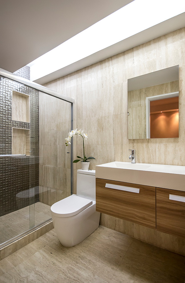Inspiration for a small contemporary 3/4 bathroom in Miami with medium wood cabinets, a one-piece toilet, beige tile, stone tile, beige walls, marble floors and an integrated sink.