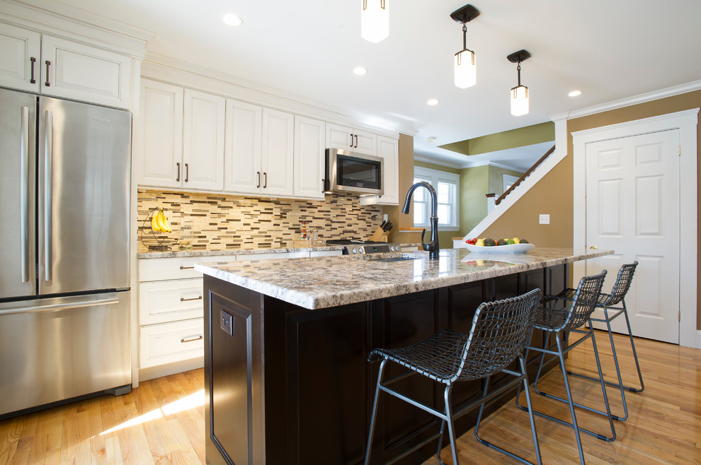 Example of a mid-sized transitional galley light wood floor eat-in kitchen design in Boston with an undermount sink, raised-panel cabinets, white cabinets, granite countertops, multicolored backsplash, ceramic backsplash, stainless steel appliances and an island