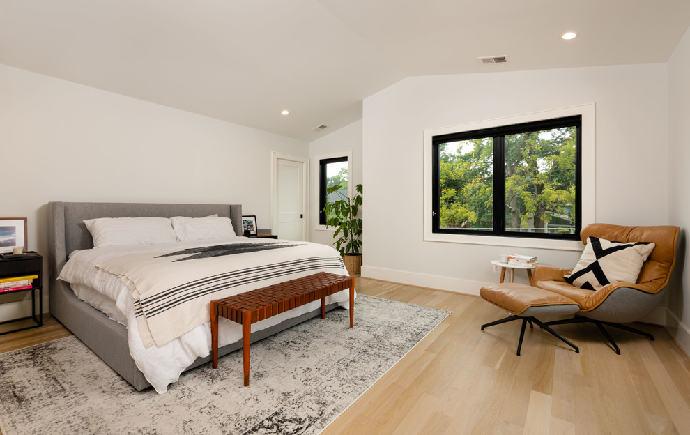 Photo of a contemporary bedroom in DC Metro with white walls, light hardwood floors and beige floor.
