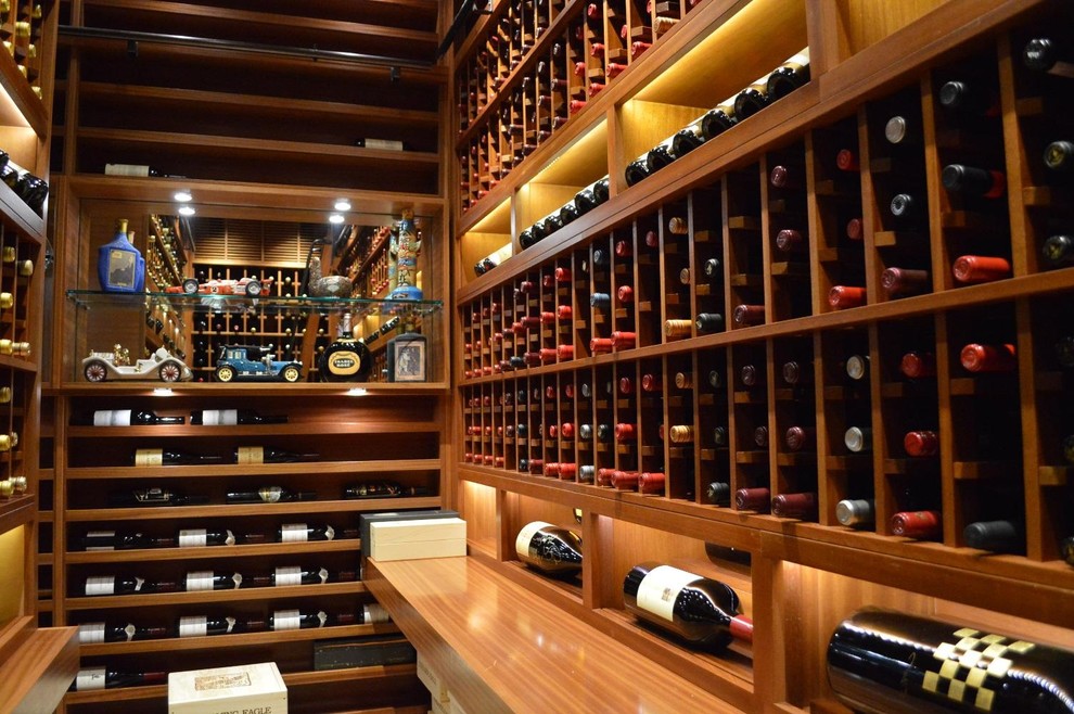 Photo of a large modern wine cellar in San Diego with terra-cotta floors and display racks.