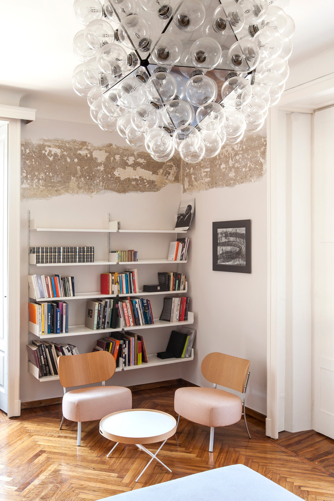 This is an example of a contemporary family room in Milan with white walls and medium hardwood floors.