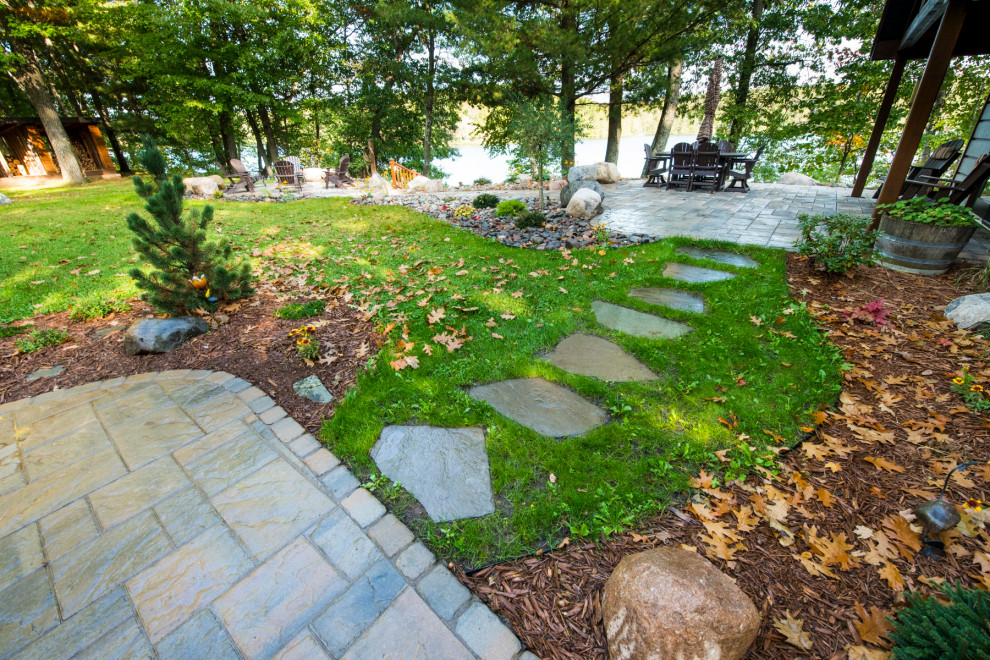 This is an example of a mid-sized country backyard partial sun garden in Other with with path and concrete pavers.