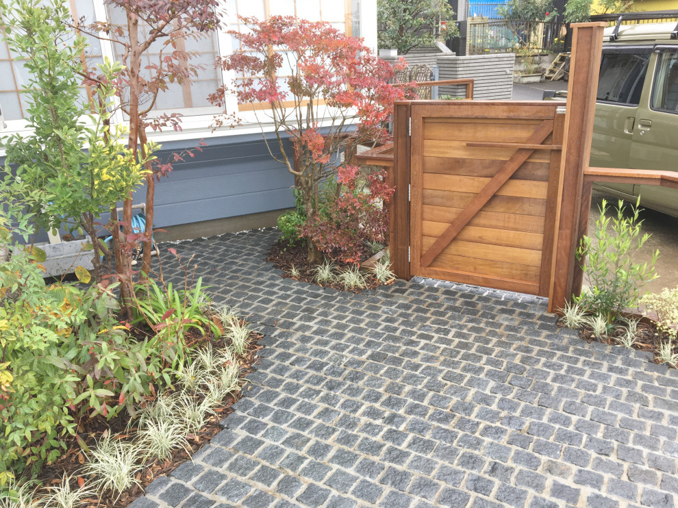Kleines Gartentor neben dem Haus mit Auffahrt, Pflastersteinen und Holzzaun in Tokio Peripherie