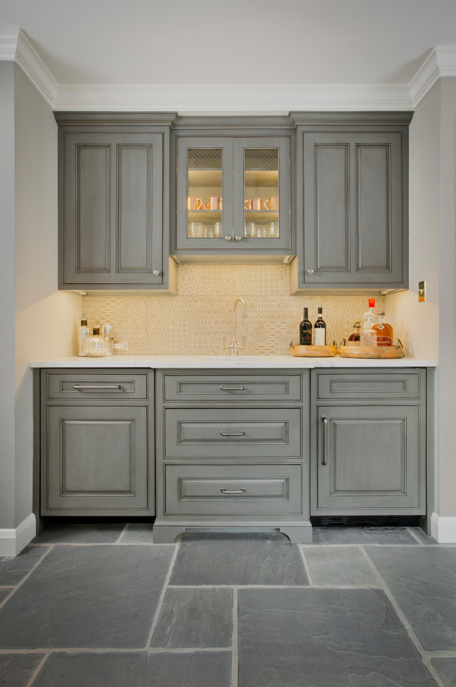Design ideas for a traditional single-wall wet bar in Baltimore with a submerged sink, recessed-panel cabinets, grey cabinets, marble worktops, yellow splashback, slate flooring, grey floors and white worktops.
