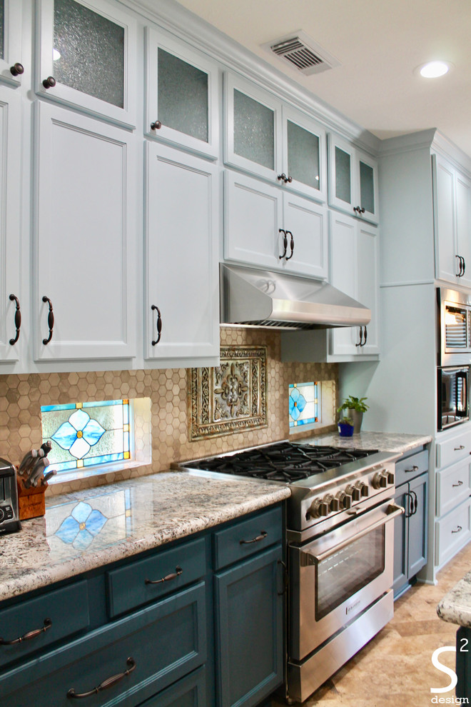 Mid-sized eclectic eat-in kitchen in Houston with an undermount sink, recessed-panel cabinets, blue cabinets, granite benchtops, beige splashback, travertine splashback, stainless steel appliances, vinyl floors, with island, beige floor and multi-coloured benchtop.