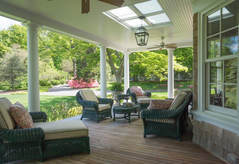 Photo of a large traditional front yard verandah in New York with decking and a roof extension.