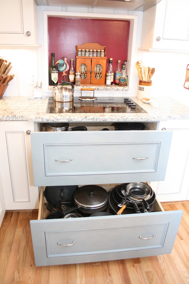 This is an example of a mid-sized country u-shaped kitchen pantry in Raleigh with flat-panel cabinets, blue cabinets, granite benchtops, with island, light hardwood floors, multi-coloured splashback and a double-bowl sink.