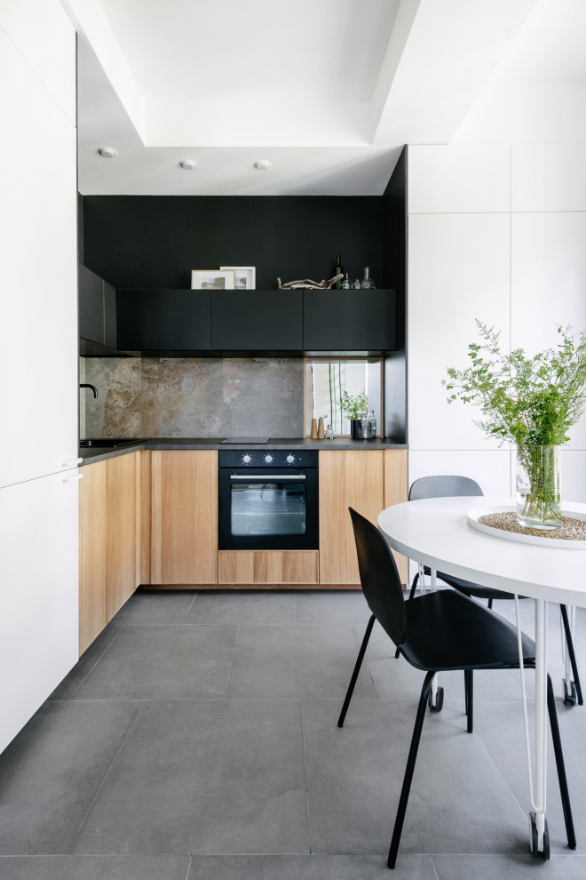 This is an example of a mid-sized contemporary l-shaped eat-in kitchen in Moscow with a drop-in sink, flat-panel cabinets, beige cabinets, grey splashback, ceramic splashback, panelled appliances, no island, grey floor and black benchtop.