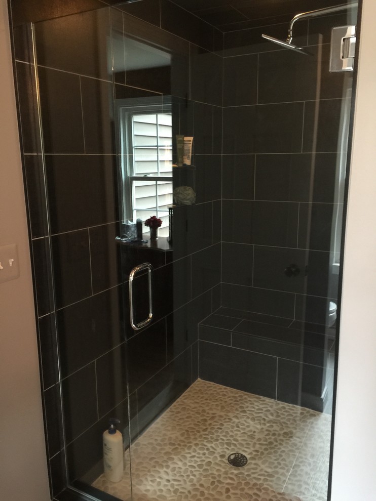 Photo of a large traditional master bathroom in Detroit with shaker cabinets, dark wood cabinets, an alcove shower, a two-piece toilet, black tile, ceramic tile, grey walls and porcelain floors.