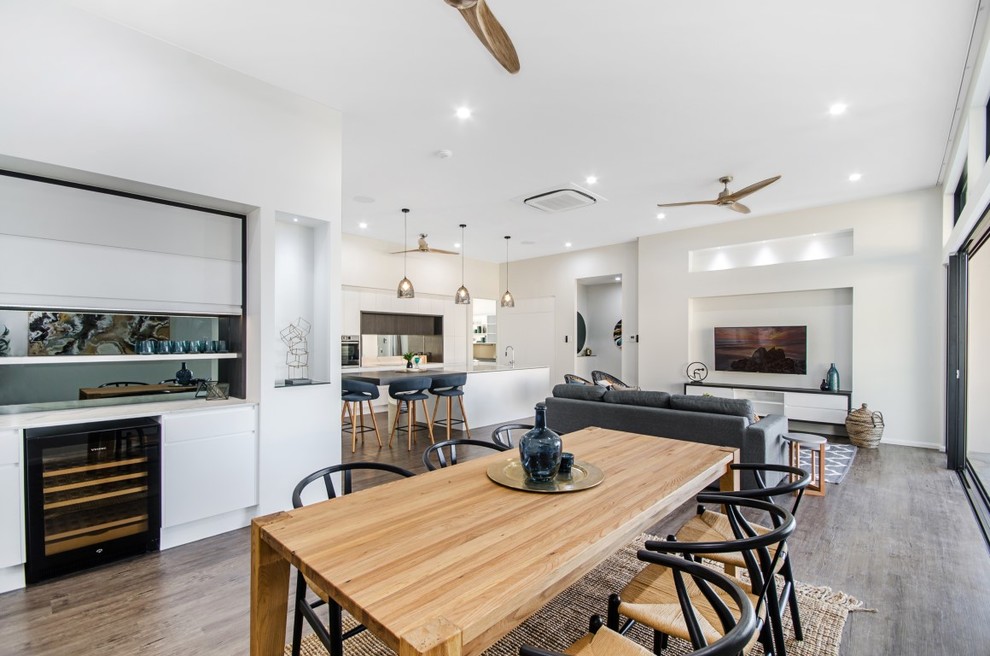 Photo of a large modern open plan dining in Townsville with white walls, vinyl floors and brown floor.