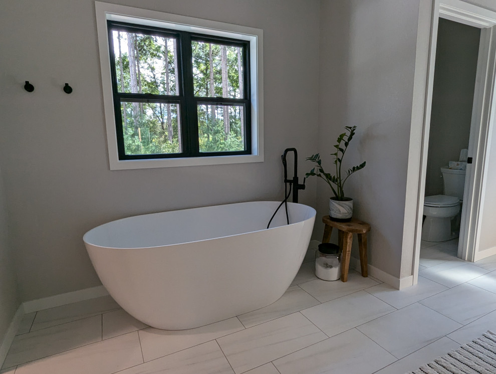 Example of a large transitional l-shaped vinyl floor and brown floor eat-in kitchen design with a double-bowl sink, shaker cabinets, light wood cabinets, quartzite countertops, white backsplash, ceramic backsplash, stainless steel appliances, an island and white countertops